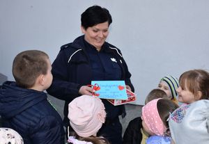 Dzieci wręczają policjantce podziękopwania