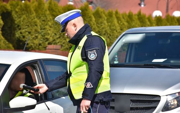Policjant kontroluje stan trzeźwości kierującego samochodem ososbowym