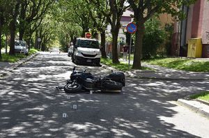 Na ulicy leży uszkodzony motocykl w wyniku wypadku drogowego
