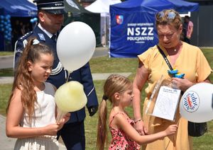 Kobieta i dzieci oraz policjant na pikniku