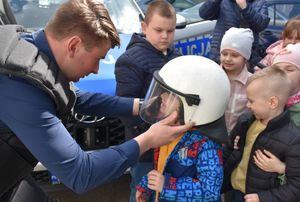 Policjant zakłada chłopcu hełm ochronnny