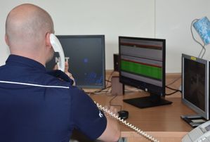 Policjant - oficer dyżurny odbiera telefon w czasie pełnienia służby