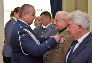 Policjant odznacza medalami policjantów oraz gości