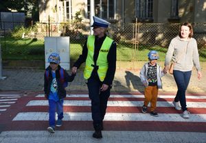 Policjantka przeprowadza przez przejście chłopca