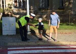 Policjant rozmawia z chłopcem przed przejściem dla pieszych