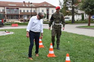 Mężczyzn w alko goglach na torze przeszkód. Za nim funkcjonariusz Żandarmerii Wojskowej.