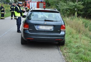 Samochód przy którym stoi policjant