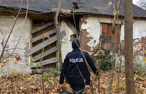 Policjanci idą w kierunku opuszczonego budynku