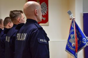 Policjanci podczas ślubowania. W tle godło i sztandar Komendy Powiatowej Policji w Jarosławiu