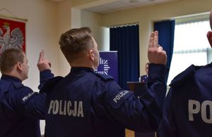 Policjant z uniesioną dłonią wypowiada rotę ślubowania