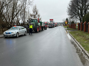 droga wraz z samochodem, policjantem i ciągnikami