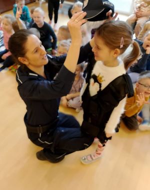 Policjanta zakłada dziewczynce czapkę