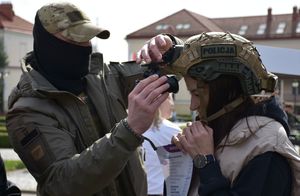 Policjant zakłada kobiecie na głowę kask