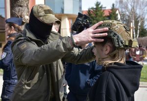 Policjant zakłada hełm uczniowi