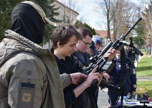 Chłopak ogląda broń w obecności policjantów