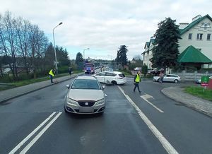 Miejsce zdarzenia drogowego. na jezdni widoczne są dwa pojazdy oraz policjanci pracujący przy zdarzeniu.