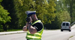 Policjant mierzy prędkość kierującym pojazdami