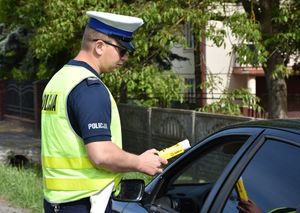 Policjant bada stan trzeźwości kierującego pojazdem