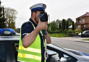 Policjant mierzy prędkość kierującemu pojazdem