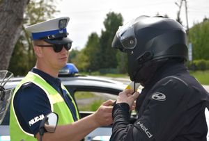 Policjant bada kierowcę motocykla na stan trzeźwości