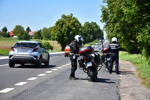 Policjanci przy motocyklach na poboczu drogi