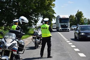 Policjant mierzy prędkość przejeżdżającym pojazdom.