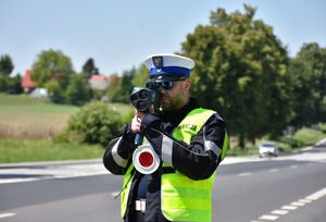 Policjant mierzy prędkość kierującemu pojazdem