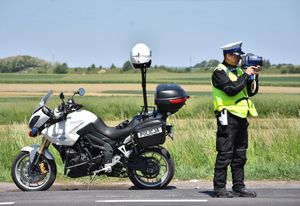 Policjant mierzy prędkość kierującemu pojazdem