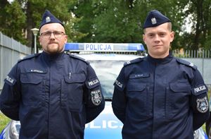 Dwóch policjantów na tle radiowzu