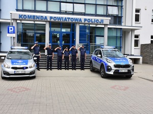 policjanci i radiowozy na tle budynku komendy policji