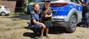 Policjantka z dzieckiem przy radiwozie