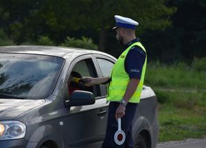 Policjant bada stan trzeźwości kierującego pojazdem