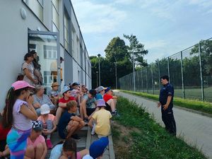 Policjantka przed szkołą rozmawia z grupą dzieci