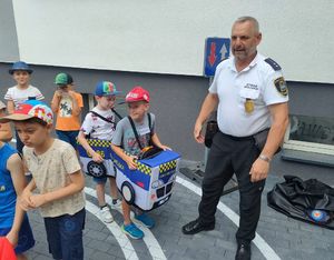 Funkcjonariusz Straży Miejskiej z dziećmi na mobilnym miasteczku rowerowym