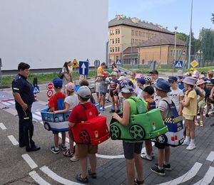 Policjantka z dziećmi na mobilnym miasteczku ruchu drogowego