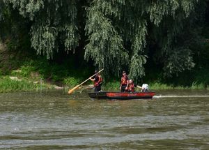 Strażacy na łódce podczas działań poszukiwawczych na rzece