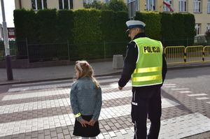 Policjant z dziewczynką na przejściu dla pieszych