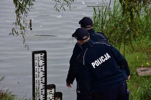 Policjanci sprawdzają stan wody w rzece