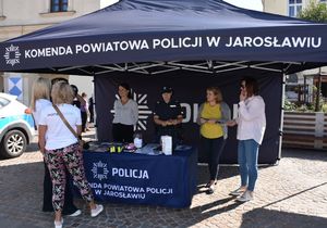 Policyjne stoisko przy którym znajdują się policjanci i uczestnicy wydarzenia