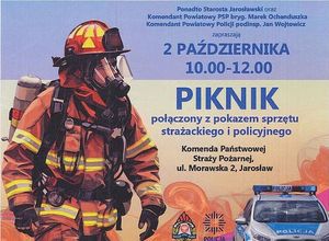 Plakat przedstawia informację odnośnie Święta Patrona Powiatu Jarosławskiego. Po lewej stronie znajduje się strażak, po prawej radiowóz.