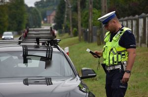 Policjant kontroluje kierującego podjazdem na stan trzeźwości