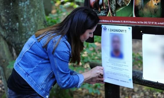 Kobieta wiesza plakat na tablicy ogłoszeń