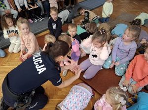 Policjanta uczy dzieci jak bezpiecznie postępować w przypadku ataku psa