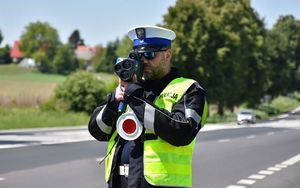 Policjant mierzy na drodze prędkość przejeżdżającym pojazdom