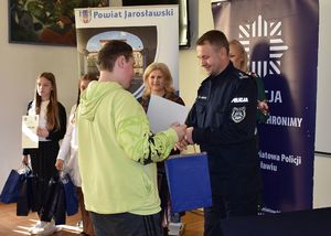 Policjant wręcza nagrodę chłopcu