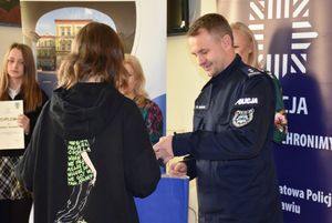 Policjant wręcza nagrodę chłopcu