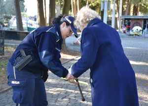 Policjantka zakłada odblask na laskę starszej kobiety