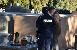 Policjantka rozmawia z mężczyzną na cmentarzu