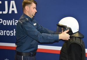 Policjant zakłada kask uczennicy