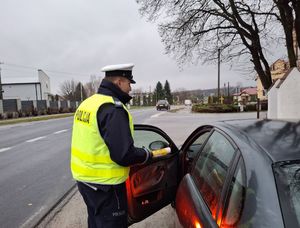 Policjant bada stan trzeźwości kierującego pojazdem